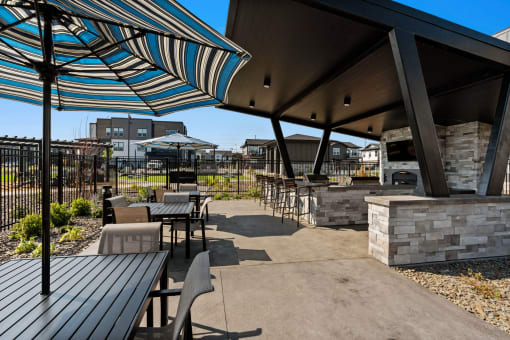 a patio with tables and chairs and umbrellas