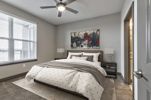 a bedroom with a bed and a ceiling fan
