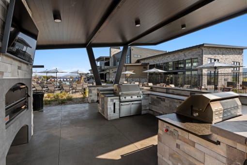 a view of the outdoor patio from the kitchen of a restaurant with a large window