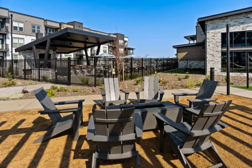a patio with chairs and tables and a building in the background