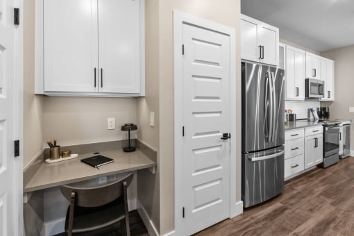 a kitchen with white cabinets and stainless steel appliances and a counter top with a refrigerator