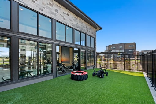 a yard with lawn bikes and a building with large windows
