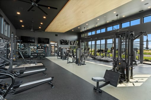 a gym with glass walls and a view of a golf course