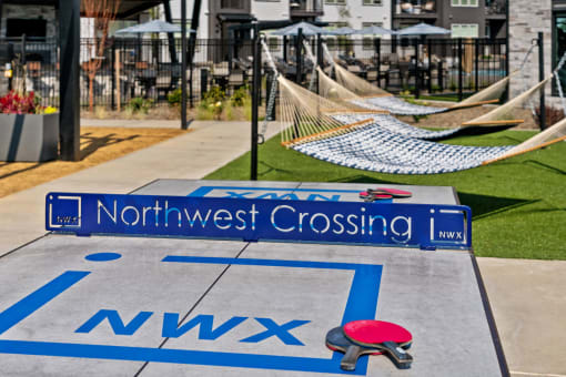 a playground with a northwest crossing sign and hammocks on the ground