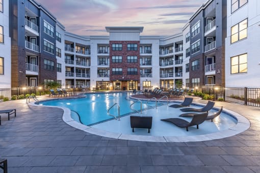 an empty swimming pool in an apartment building at dusk