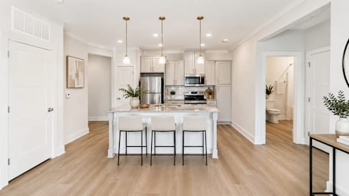 A kitchen with a table and chairs in the middle of the room.