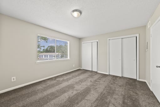 an empty living room with carpet and a window