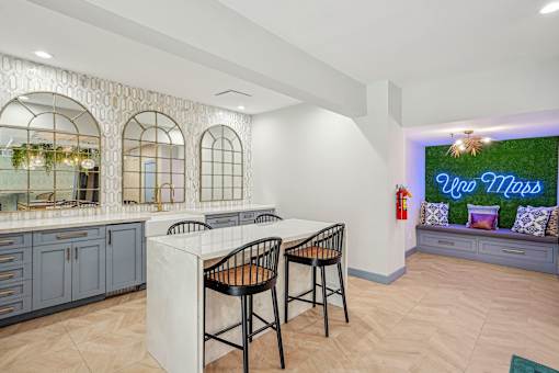 A kitchen with a white island and two chairs.
