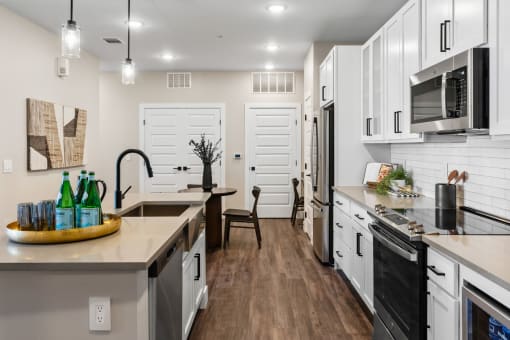 an open kitchen with a large counter top and a sink