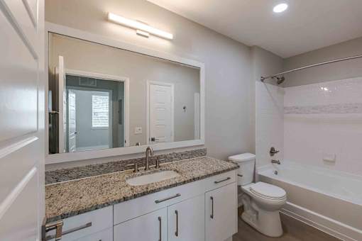 A bathroom with a sink, toilet, and bathtub.