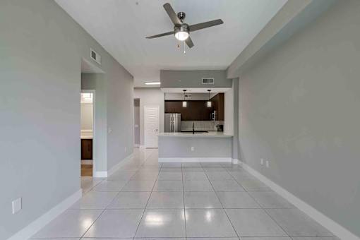 A spacious room with a ceiling fan and tiled flooring.