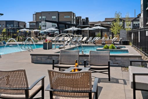 a swimming pool with chairs and tables next to a hotel pool