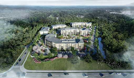 an aerial view of a building surrounded by trees and a highway