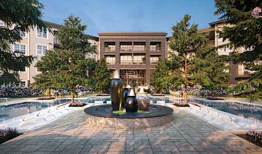 a fountain in the middle of a pool with a building in the background