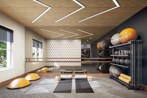 a gym with a variety of weights and yoga mats