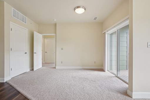 A room with a white carpet and a ceiling light.