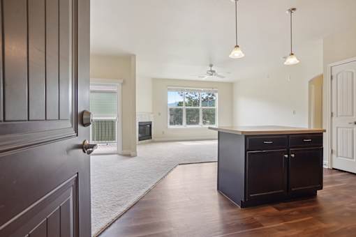 A modern kitchen with dark wood floors and a large island.