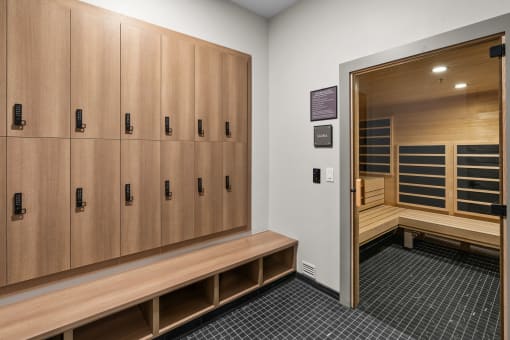 a locker room with wooden lockers and benches and a bench next to a door