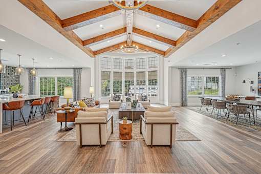 A spacious living room with wooden floors and a high ceiling.