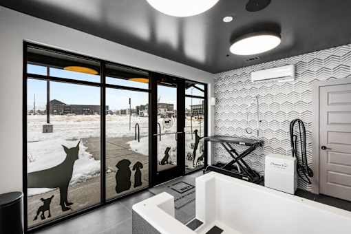 A bathroom with a large mirror and a dog silhouette on the window.