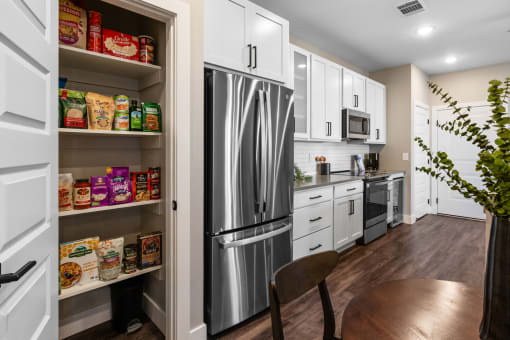 a kitchen with white cabinets and a stainless steel refrigerator