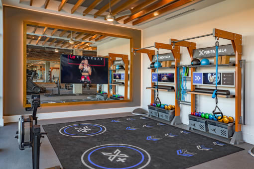a workout room with weights and ropes and a scoreboard