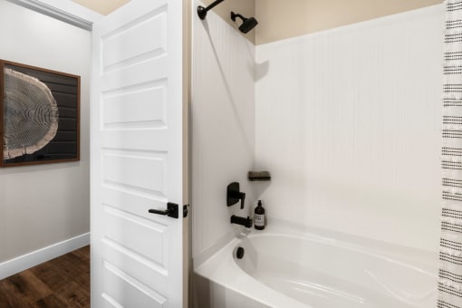 a bathroom with a bath tub and a white door