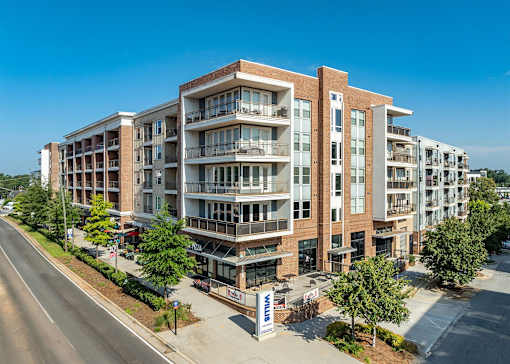 A large apartment building with a blue sky in the background.