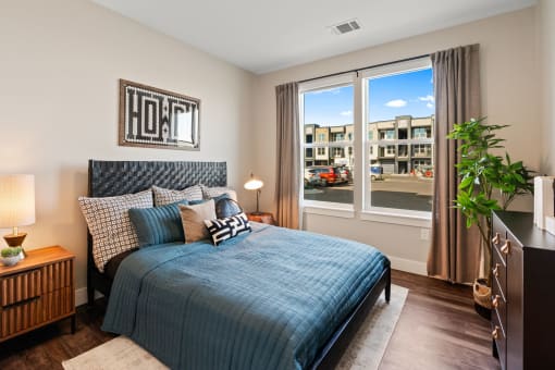 a bedroom with a bed and a window with a city view