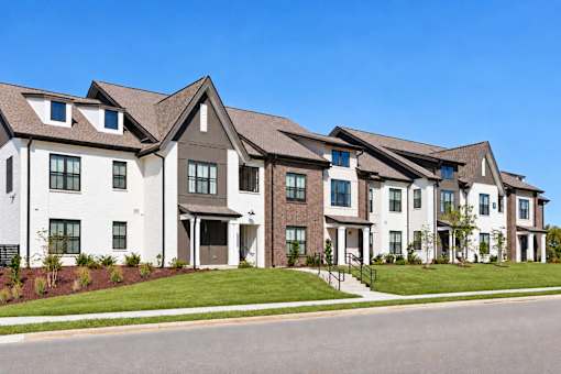 A row of modern houses with white and brown exteriors.