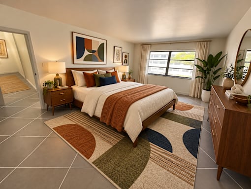 A bedroom with a large bed and a rug in front of it.