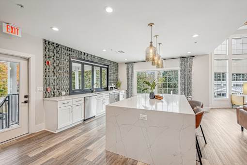 A kitchen with a white island and a chandelier.