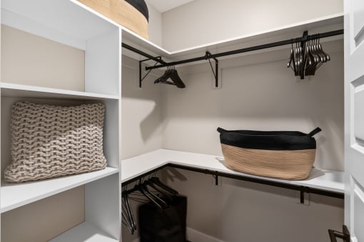 a walk in closet with shelves and a basket on a shelf