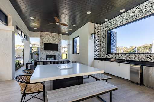 A modern outdoor kitchen with a table and chairs.
