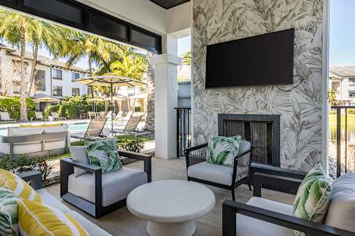 A patio with a white table and chairs with green cushions.
