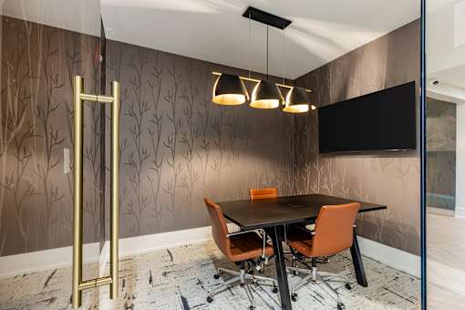 A conference room with a brown wallpaper and a blackboard.