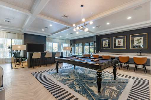 A large room with a pool table and chairs.