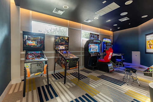 A room with a striped carpet and arcade games.
