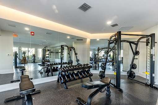 A gym with a variety of equipment including weights and machines.