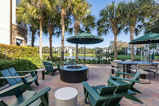 A patio with green chairs and tables.