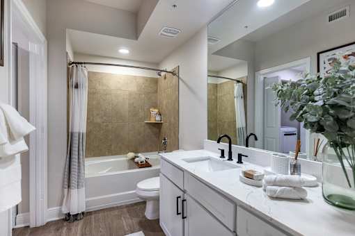 A modern bathroom with a white color scheme and a large mirror.