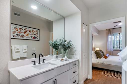 A bathroom with a white sink and a mirror above it.