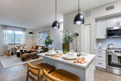 A modern kitchen with a dining area and a living room.