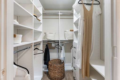 A white closet with a beige dress hanging on the rack.