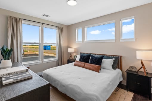 a bedroom with a bed and three windows