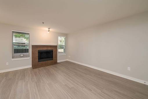 A room with a fireplace and wood flooring.