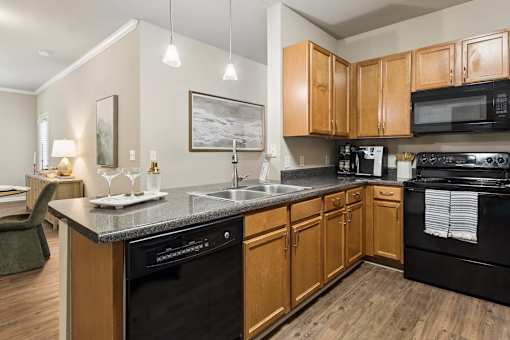 A kitchen with wooden cabinets and black appliances.