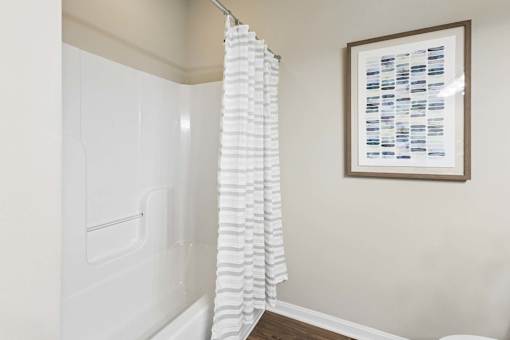 A white shower curtain hanging in a bathroom.
