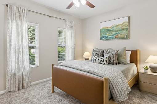 A bedroom with a bed, nightstand, and a painting on the wall.