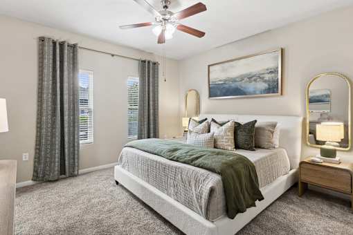 A bedroom with a large bed and a ceiling fan.